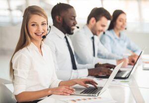 two women and two men working together typing on a laptop